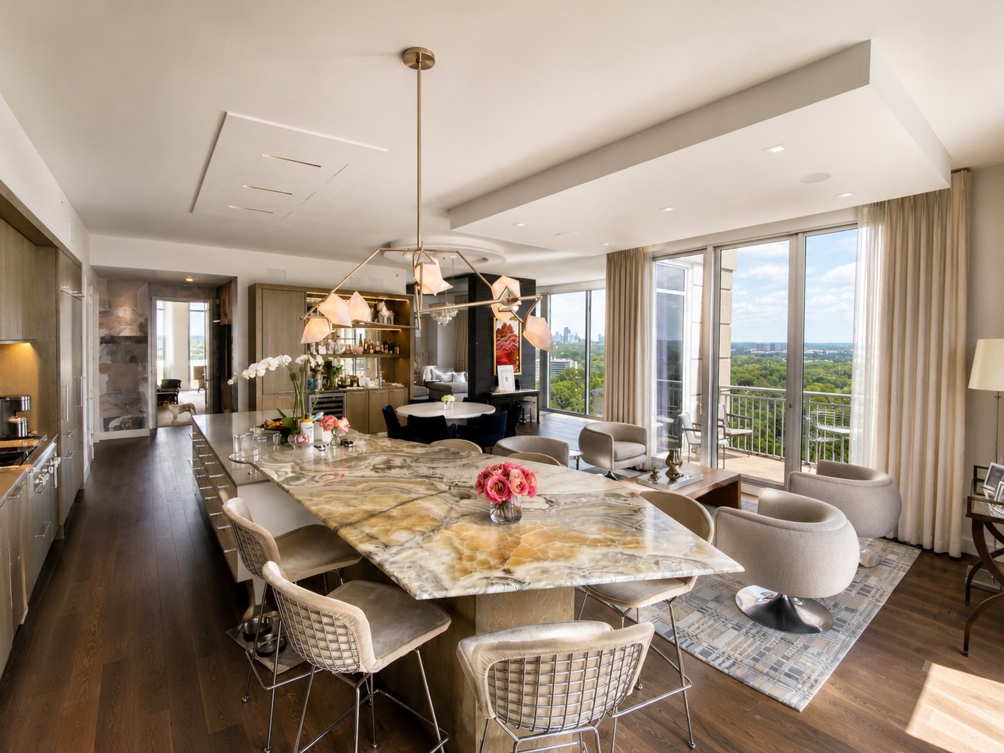 Kitchen with book-matched stone island table, professional range and metallic surround